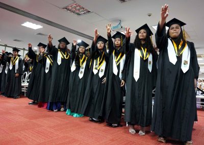 Estudiantes con togas de graduación de bachillerato durante ceremonia de grado en Bogotá